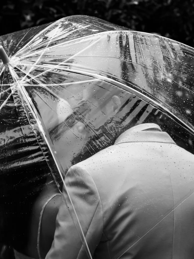 Bride and groom photographed outdoors in light rain at a Kent wedding