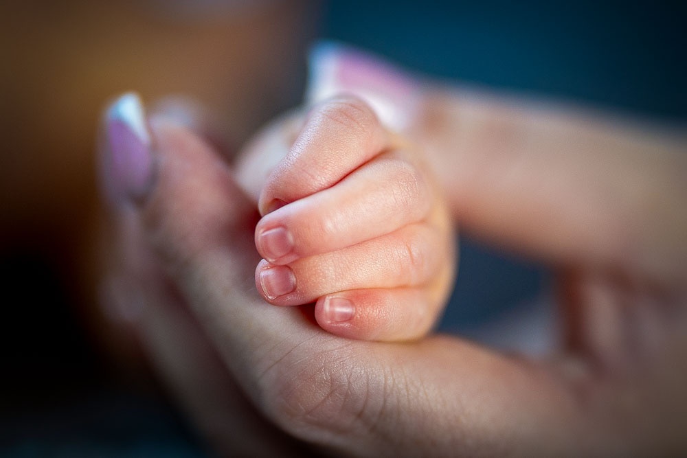baby's hand held by mum and photographed by Marcus The Photographer